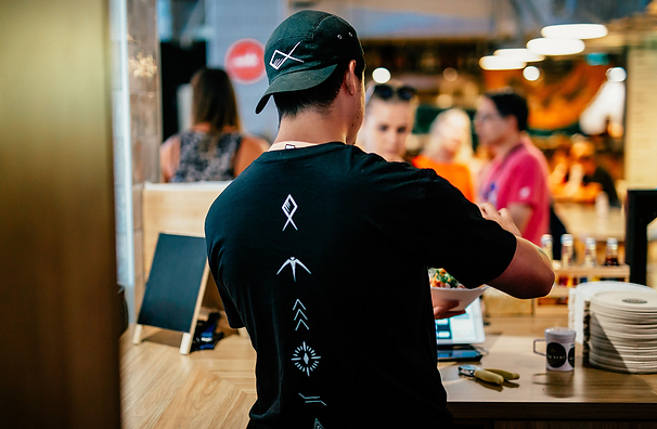 The co-founder of Ika Bowl serving a bowl to a customer